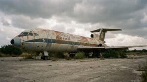 A rusted passenger jet sitting abandoned on the tarmac of the Nicosia Airport forbidden zone.